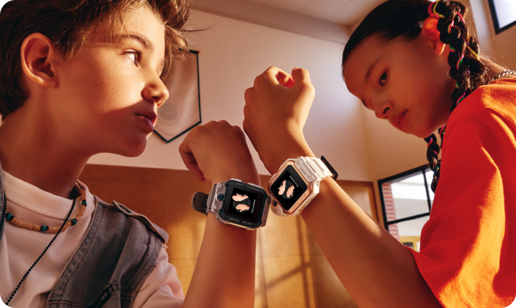 Junge und Mädchen zeigen ihre imoo Z7 Smartwatches im Fitnessstudio, beide mit Schmetterlings-Icon auf dem Display.